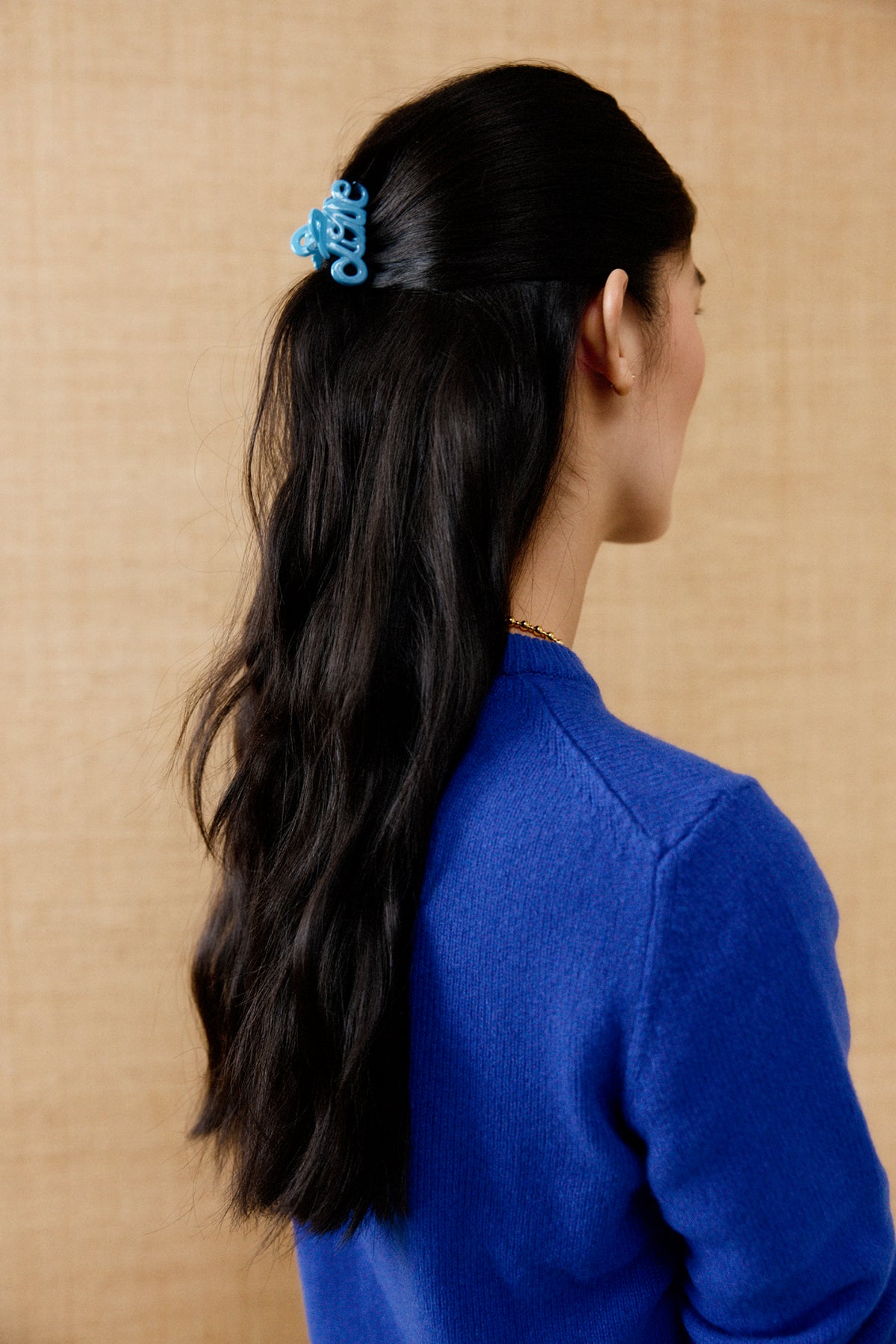 Pince à cheveux Love Claw bleue BON DEP portée sur des cheveux bruns attachés en demi-queue