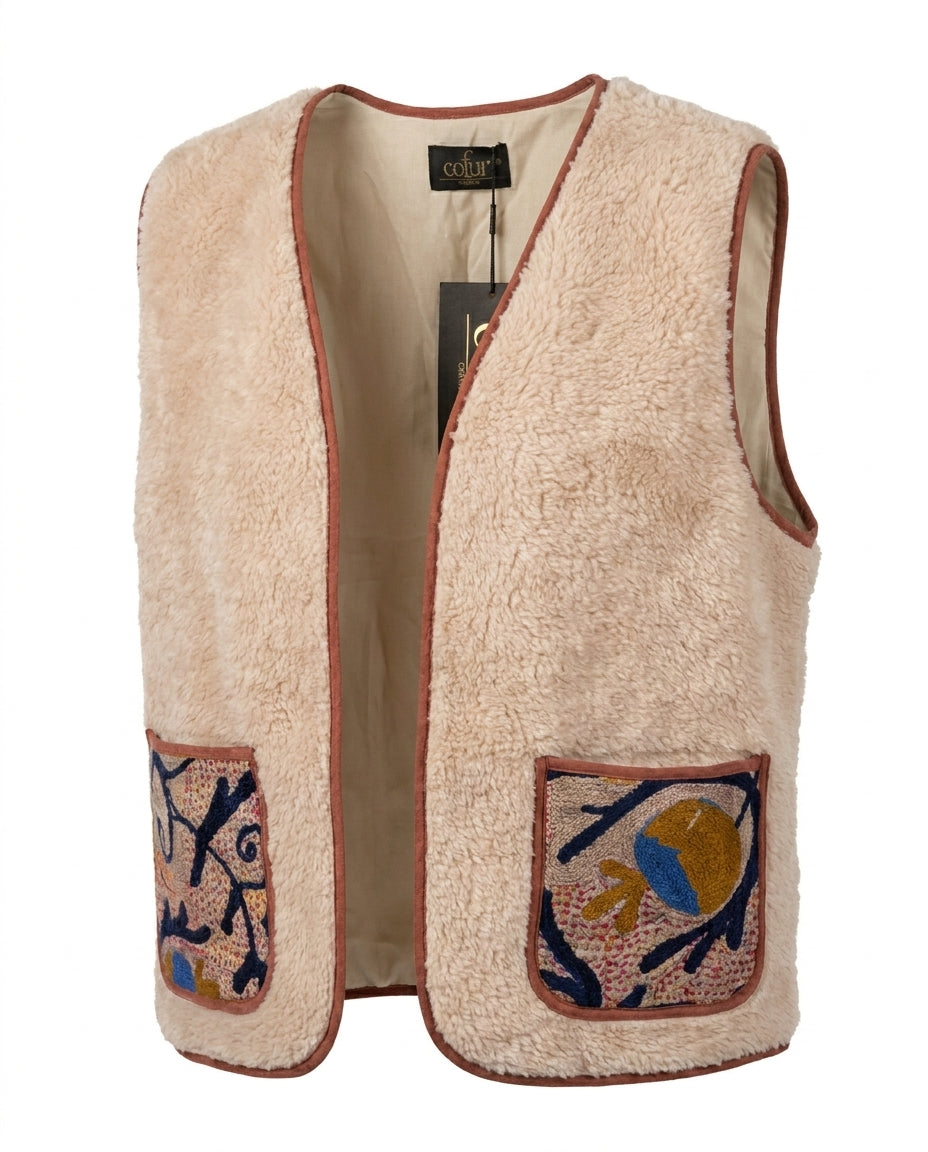 Gilet Cofur en sherpa écru à biais terracotta, poches brodées d'un oiseau ocre et bleu sur branches bleu nuit, vue de face
