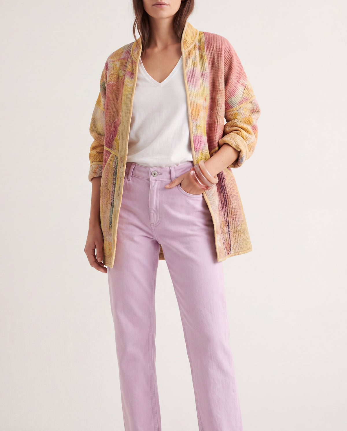 Veste kantha Cofur abricot et rose pâle portée ouverte sur un t-shirt blanc et un jean lilas