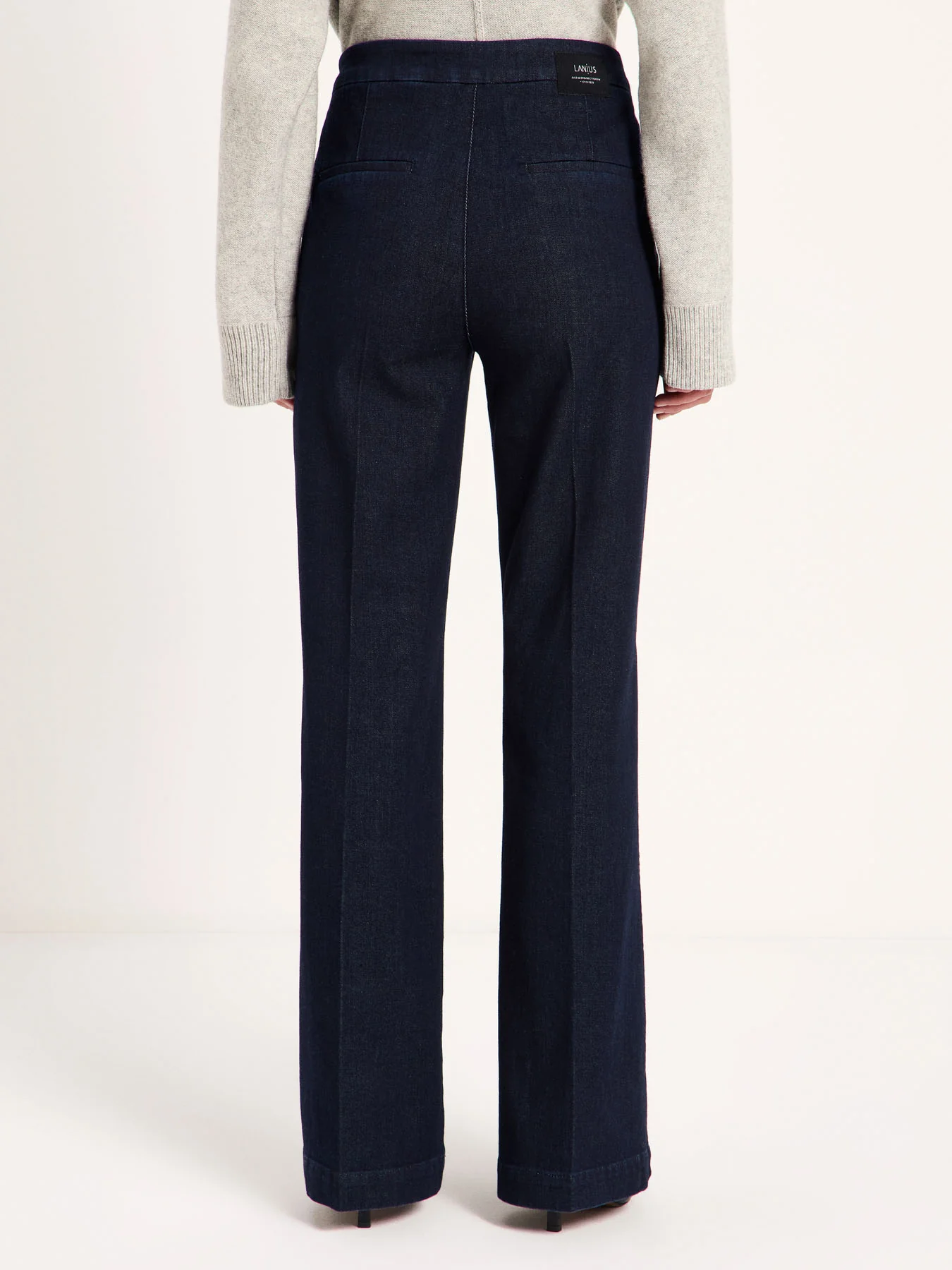 Détail des jambes évasées et des plis marqués du jean Willow LANIUS Denim brut