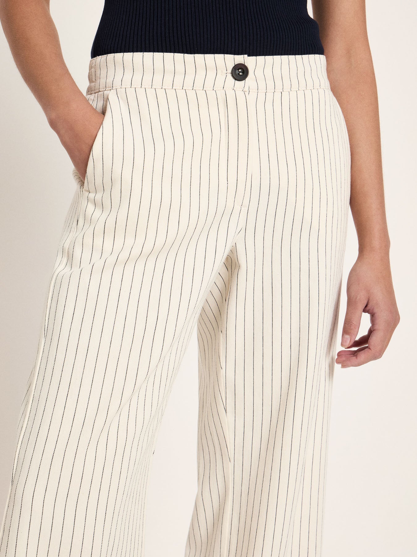 Gros plan sur la taille boutonnée et la poche du pantalon rayé écru LANIUS, mannequin main en poche