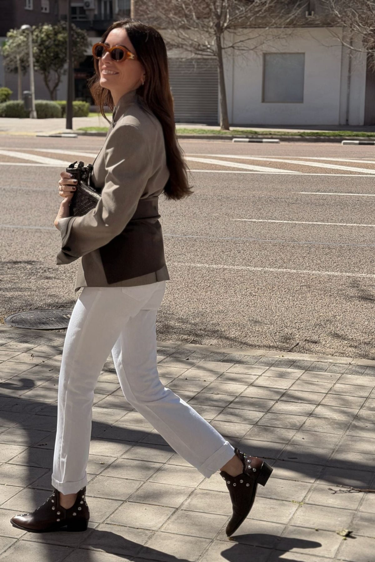 Femme marchant en bottines MICUIR Punky chocolat avec un jean blanc et un blazer