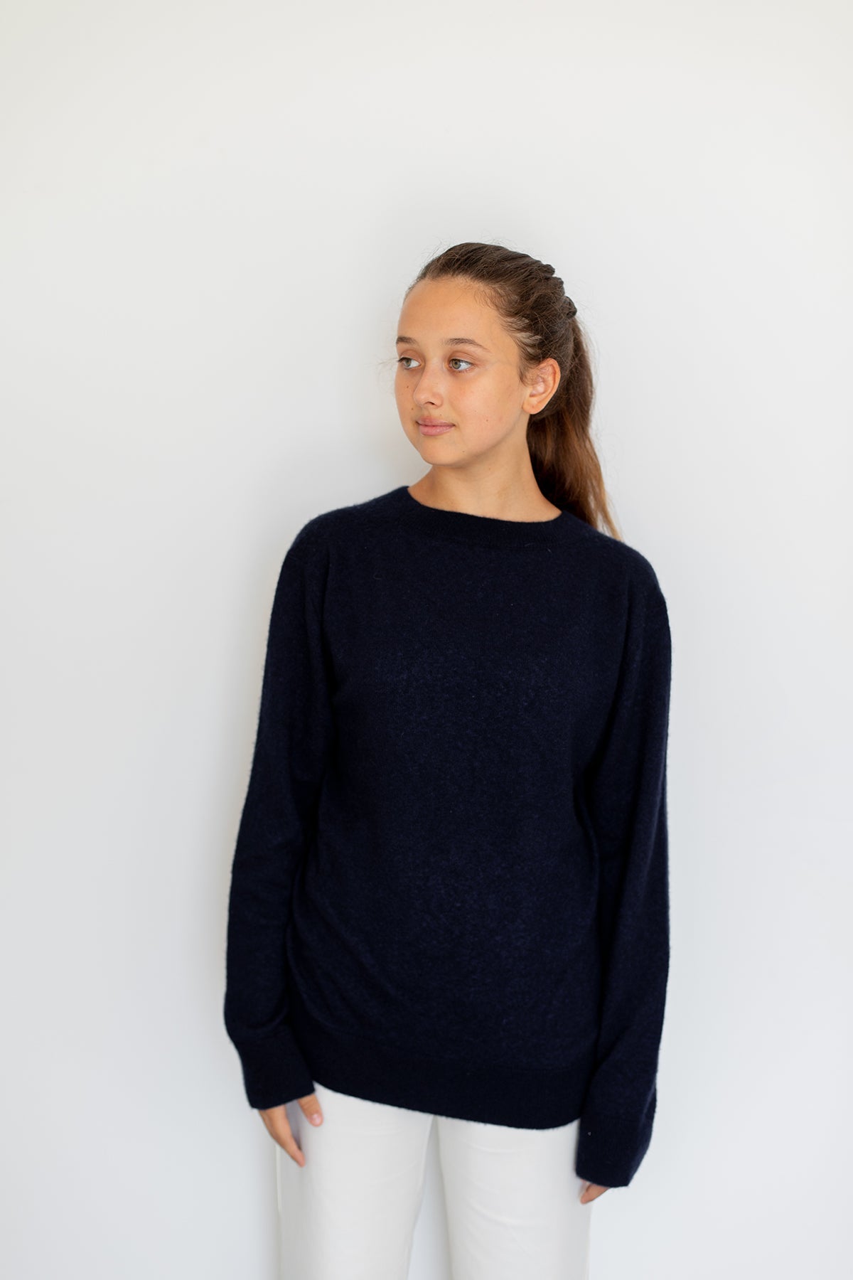 Pull col rond Nuage Cashmere en Indigo, porté de face sur un pantalon blanc