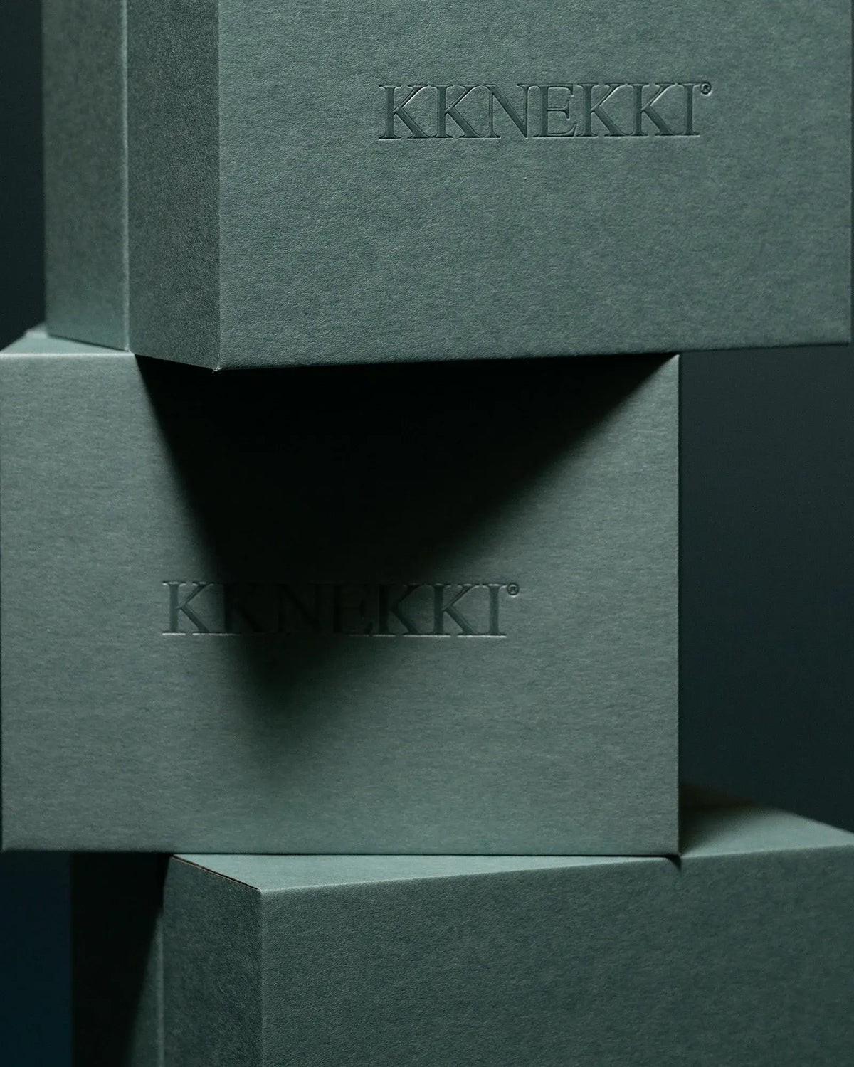 Trois boîtes cadeau Kknekki vert d'eau empilées, logo Kknekki embossé sur le couvercle