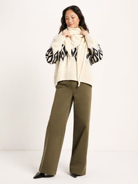 Écharpe triangle laine et coton bio LANIUS Blanc cassé nouée sur un cardigan jacquard et un pantalon kaki