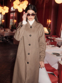 Manteau à carreaux LANIUS Noir & beige porté boutonné avec un col roulé blanc, dans un restaurant