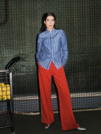 Pantalon à bandes contrastées LANIUS Rouge feu porté avec une chemise rayée bleue