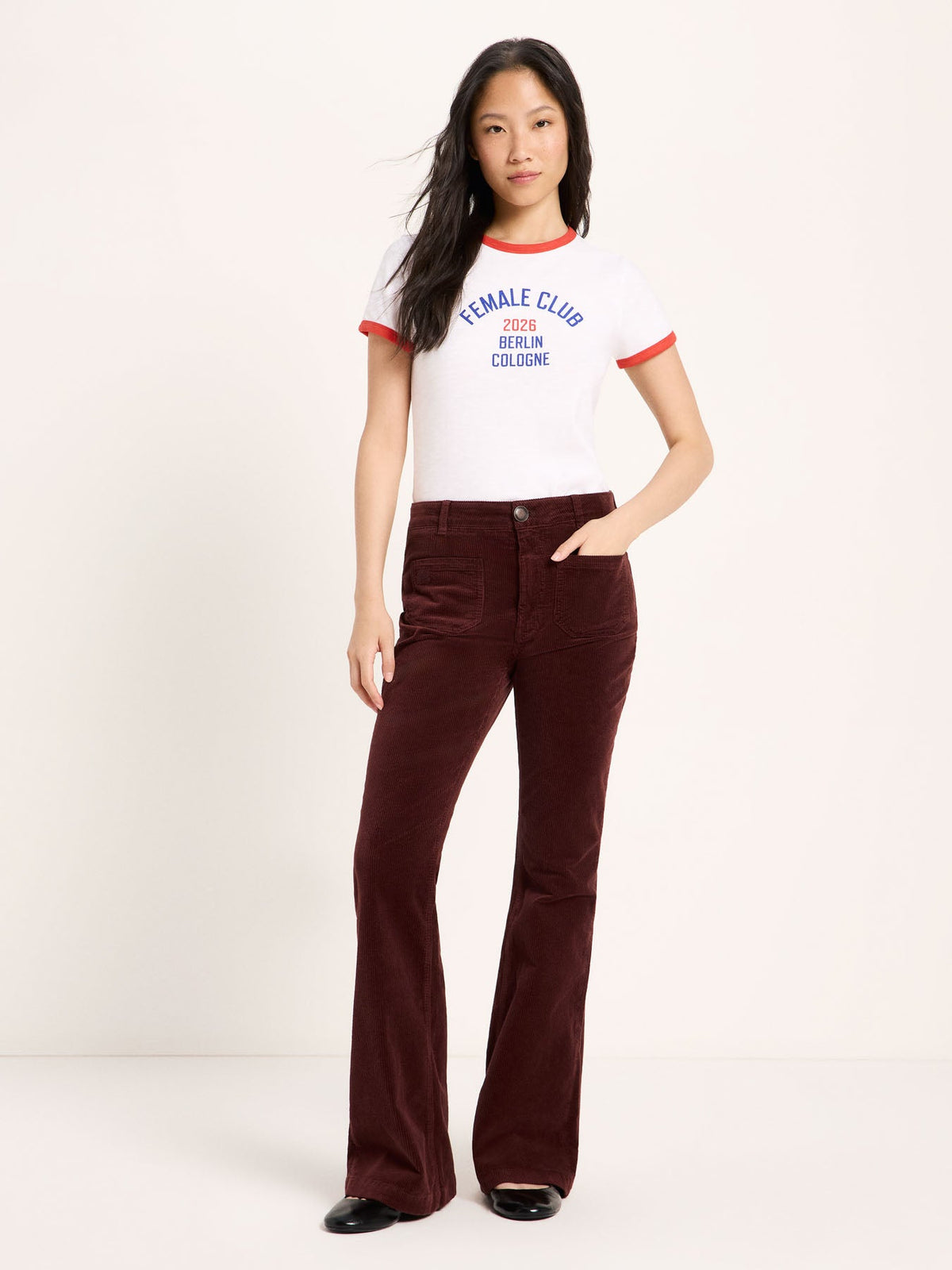 Pantalon flare en velours côtelé coton bio LANIUS Chocolat – vue de face, avec un t-shirt blanc à liseré rouge