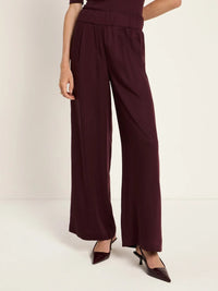 Pantalon fluide LANIUS Bordeaux, jambe large portée avec des escarpins vernis – détail de la jambe