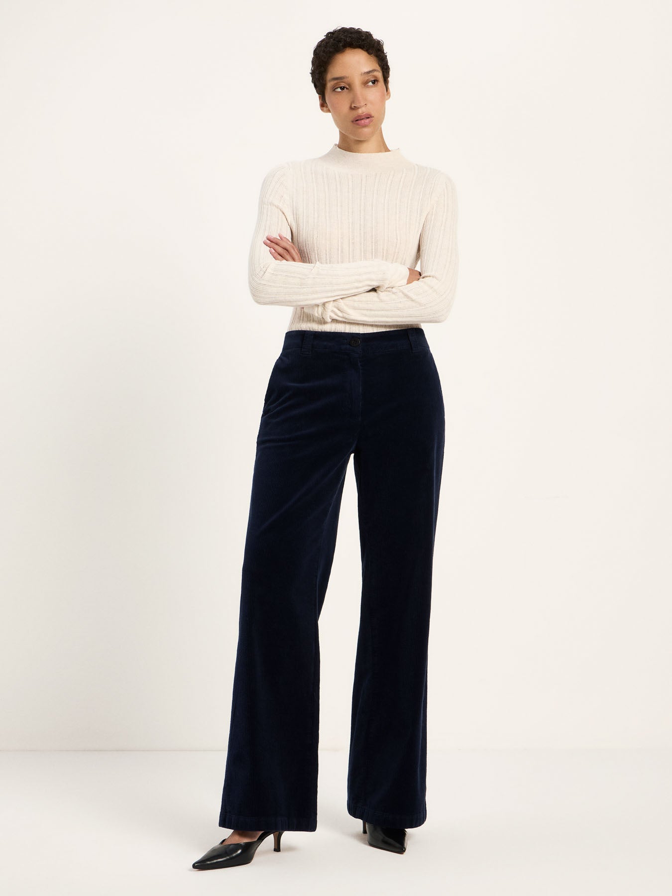Pantalon Marlene en velours côtelé LANIUS Bleu nuit porté avec un pull crème – vue de face