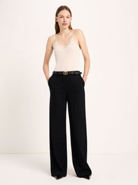 Pantalon Marlene en flanelle de laine et coton bio LANIUS Noir – vue de face, avec un caraco crème et une ceinture fine