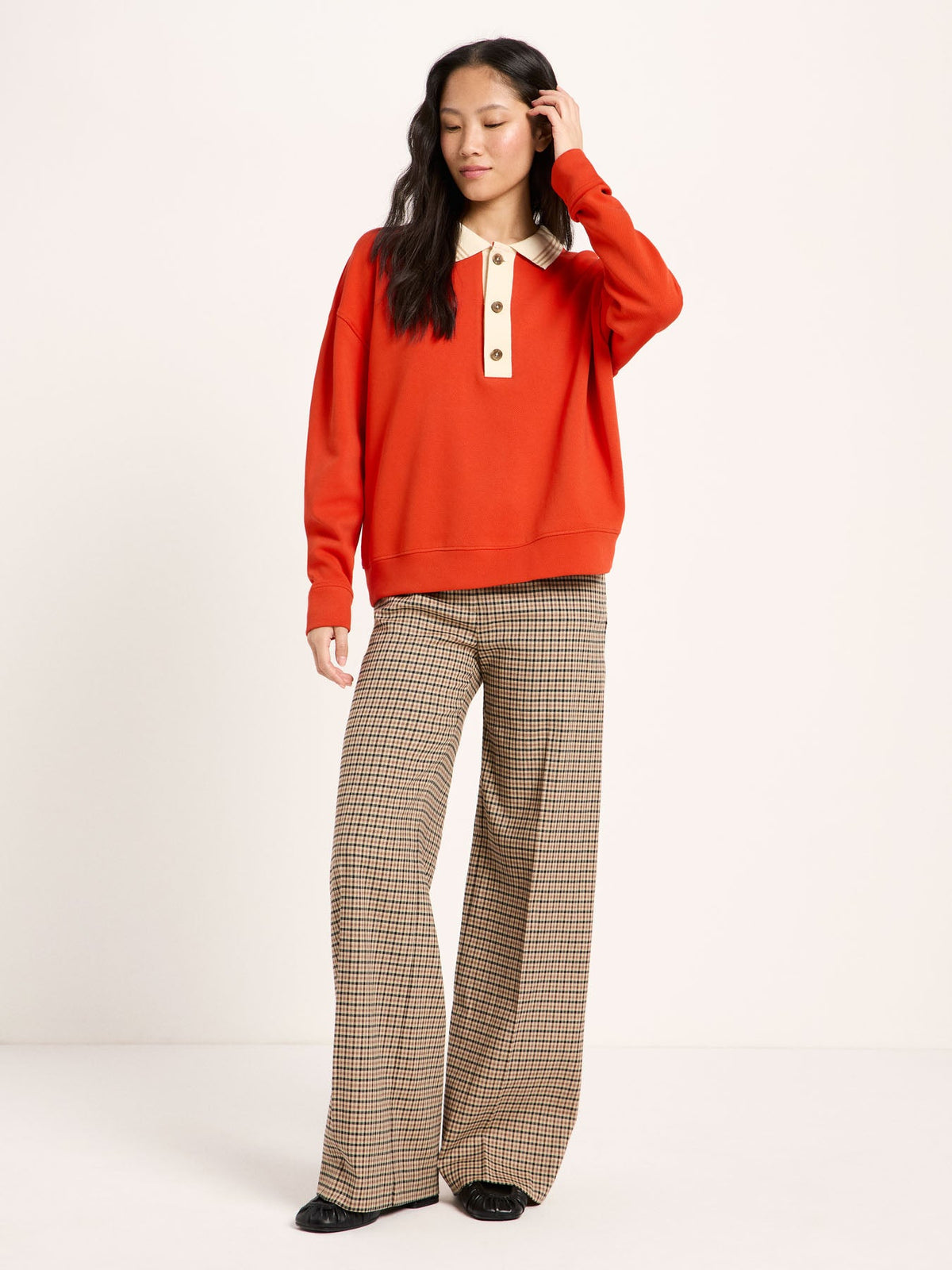 Sweat col polo LANIUS Rouge feu porté avec un pantalon large à carreaux – look complet