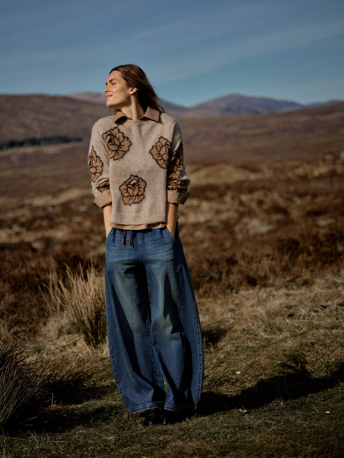 Pull à roses jacquard MOS MOSH Doeskin porté en extérieur dans un paysage de lande – vue en pied