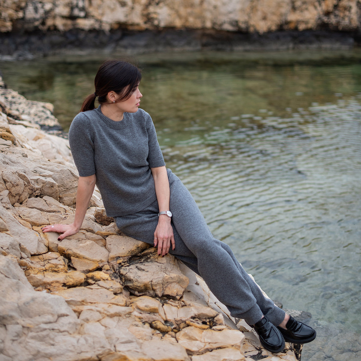 Jogging en cachemire Nuage Cashmere gris, porté assise sur les rochers