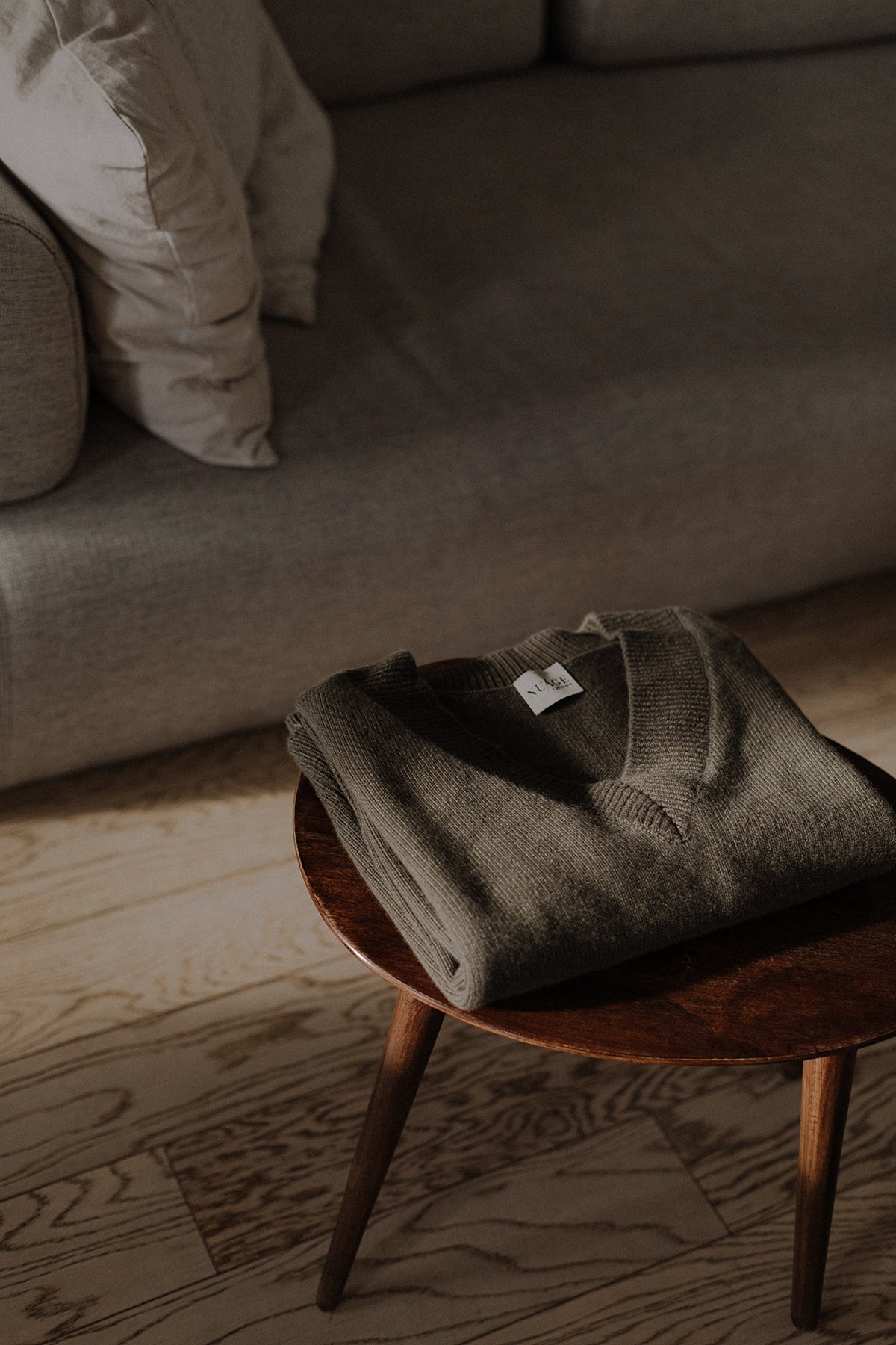 Pull col V Iconic Nuage Cashmere en Olive, porté de face sur un pantalon blanc