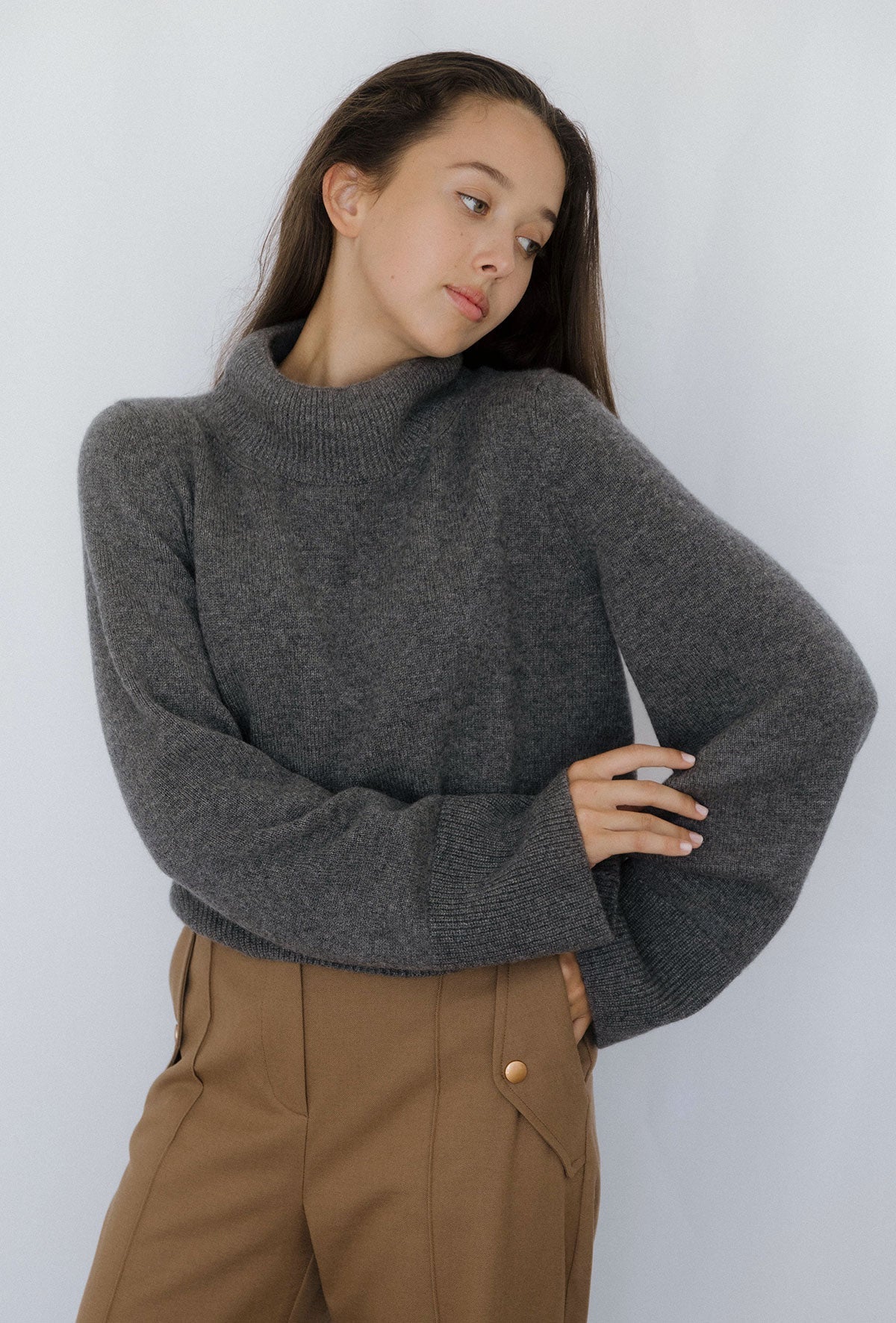 Pull manches larges Nuage Cashmere en Grey, porté de profil, main sur la hanche